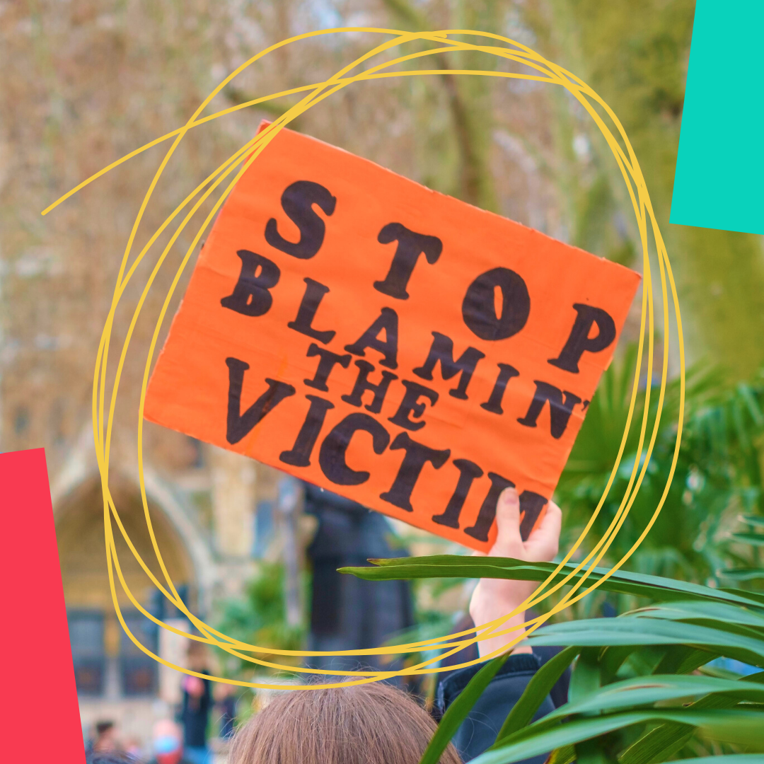 A placard that says 'stop blaming the victim'