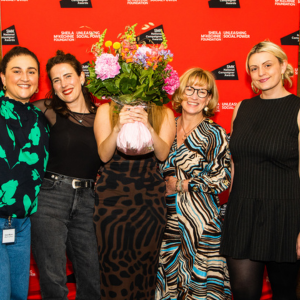 Jodie holding a bouquet of flowers in front of her face to preserve her anonymity, standing with Elena Michael from #NotYourPorn, Rebecca Hitchen from the End Violence Against Women Coalition, Professor Clare McGlynn, and journalist Lucy Morgan